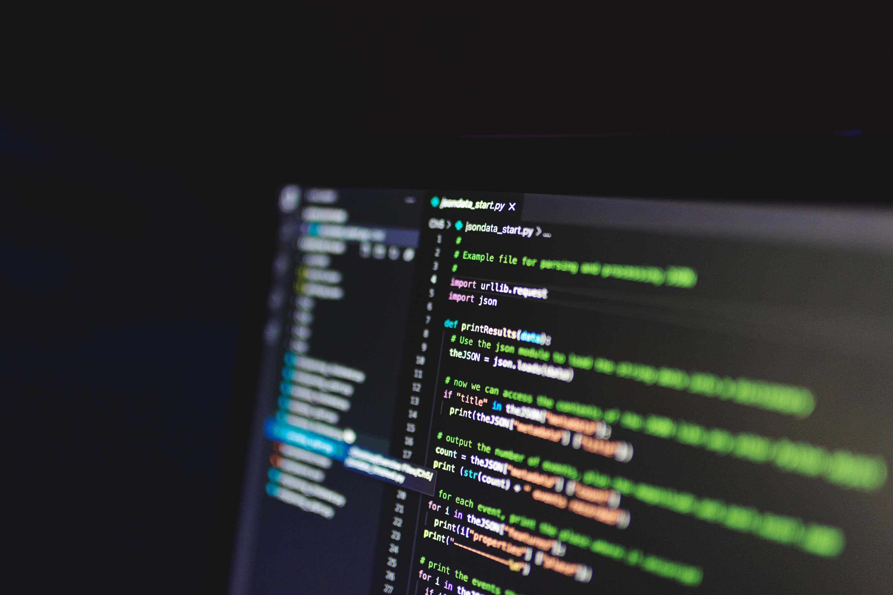 Programmiercode auf einem Bildschirm in einem abgedunkelten Raum